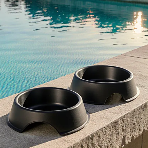 A stylish, glass dog bowl with a sleek design resting on a marble counter while a relaxed golden retriever licks the rim